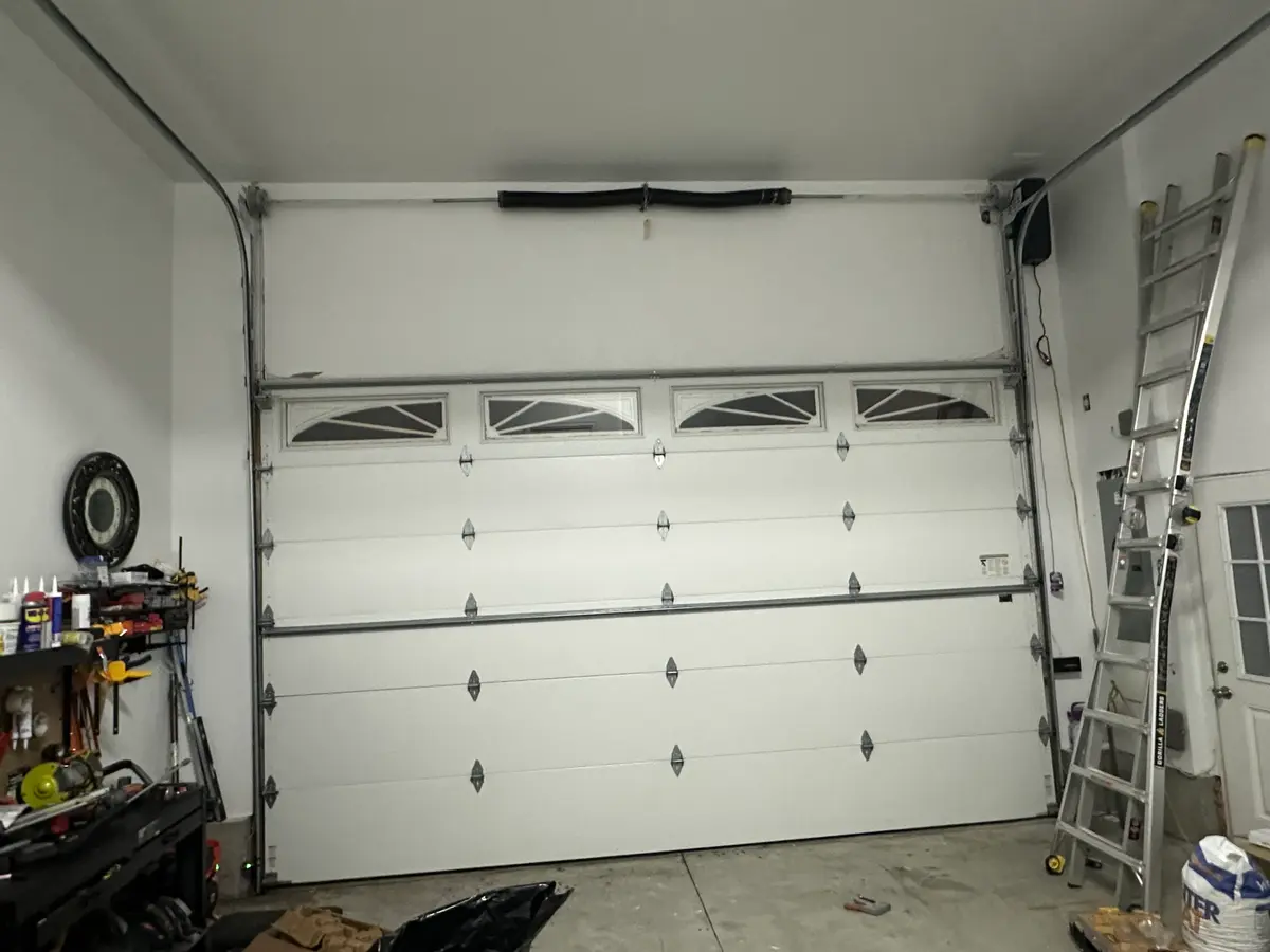 Newly installed insulated steel garage doors on a finished home